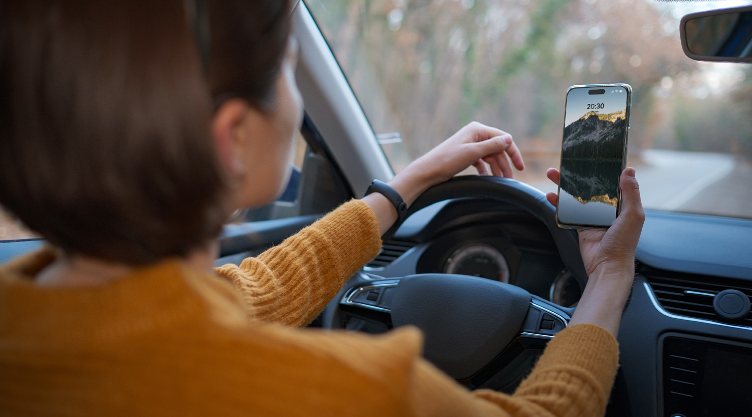 woman holding phone while driving